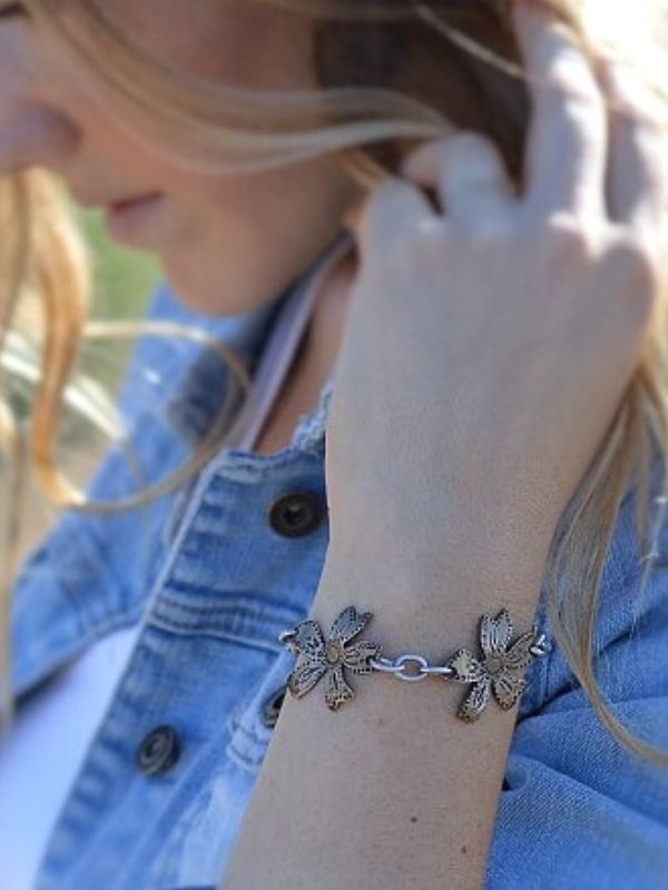 triple metal wildflower bracelet on arm