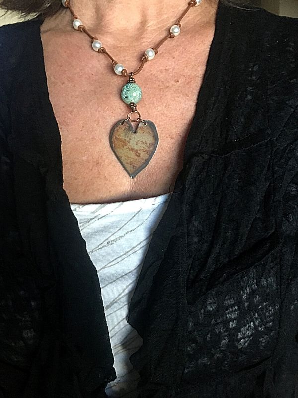 wearing black jacket and big rustic heart statement necklace
