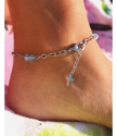 Barefoot on a beach towel with a crystal and cross anklet