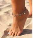 barefoot on the sand with a silver multi heart anklet