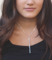 gold & silver stick necklace on dark haired models neck