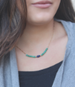 blue & green gemstone gold chain necklace on dark haired model