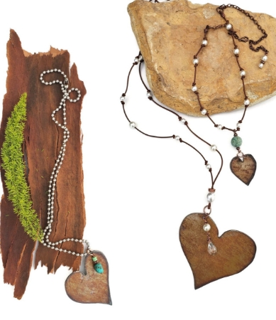 3 copper heart necklaces on wood and stone
