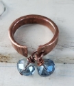  top view of hammered copper cuff ring with blue crystals on white distressed wood