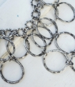 close up silver circle bib necklace on white distressed wood