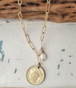 Gold chain coin necklace with white pearl on white wood