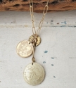 Gold Coin cluster necklace on white distressed wood