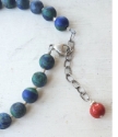 Bright red coral stone on back of blue gemstone necklace