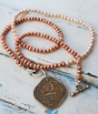 Indian coin pearl necklace on white distressed wood