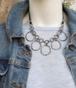 Silver textured circle chain statement necklace on mannequin with jean jacket