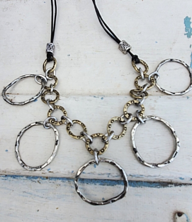 Textured silver and gold chain clusterstatement necklace on white distressed wood