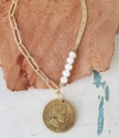 Mixed gold chain pearl coin necklace on white wood