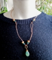 Turquoise black tan gemstone copper loop necklace on black top on mannequin