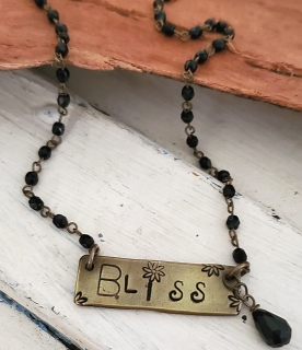 Brass bliss bar necklace with black beaded chain on wood