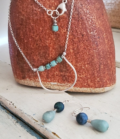 Blue stone silver chain necklace earring set on vase