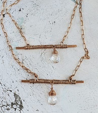 wired wrapped bronze bar crystal chain necklaces on white distressed wood
