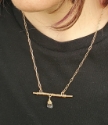 model wearing bronze bar necklace with centered stone