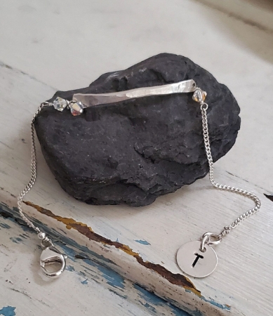 Silver bar initial tag charm birthstone bracelet on black rock
