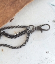 Extra big swivel hook clasp black multi chain bracelet on table