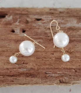 white big pearl little pearl drop earrings on wood