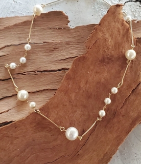 asymmetrical white pearl gold bar floating necklace on wood