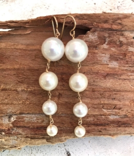 long white pearl graduated earrings on wood