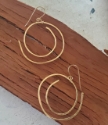 gold spiral earrings on wood