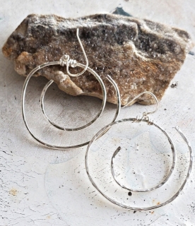 Sterling silver spiral earrings on distressed table