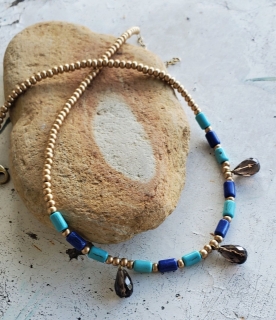 blue turquoise gold smokey quartz beaded necklace on rock