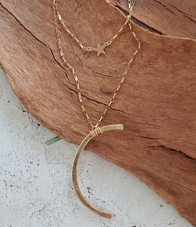 gold star and moon necklaces on wood