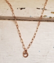 Single bronze ring paperclip chain necklace white distressed wood