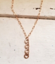 Four bronze ring paperclip chain necklace white distressed wood