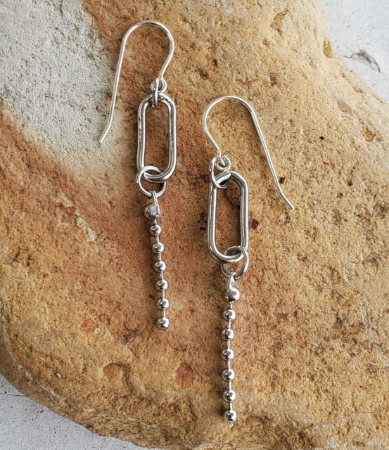 silver oval link bead ball chain earrings on rock