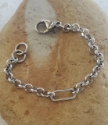 silver oval shape rolo chain bracelet on rock