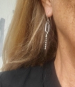 model wearing silver big oval with chain earrings