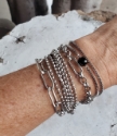 wearing 4 modern silver chain bracelets on wrist