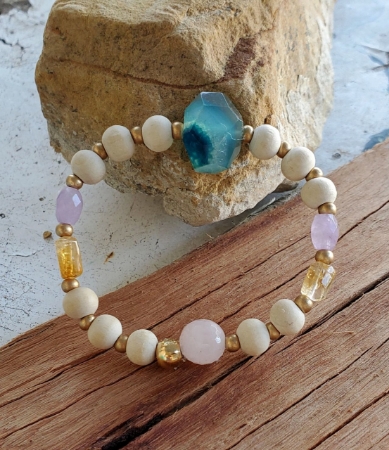 Pastel gemstone bracelet on wood and rock