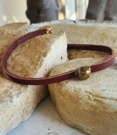 brown red leather brass designed bead choker necklace on rocks