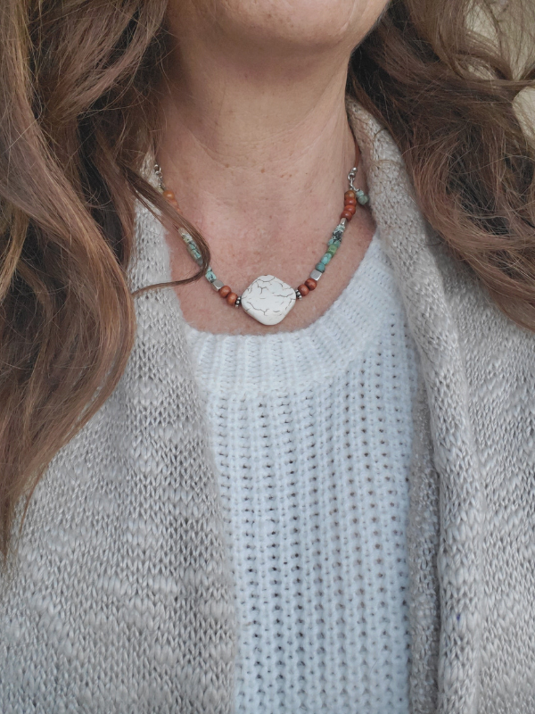 earthy gemstone necklace worn with white sweater