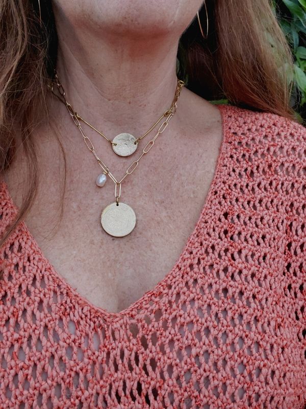 Coral knit sweater with layered coin necklaces