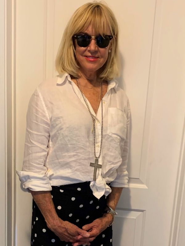 wearing polka dot skirt white wrinkled blouse and long necklace