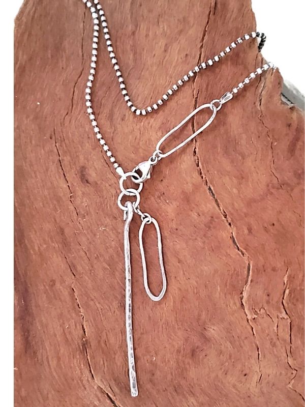 artisan silver asymmetrical necklace on wood