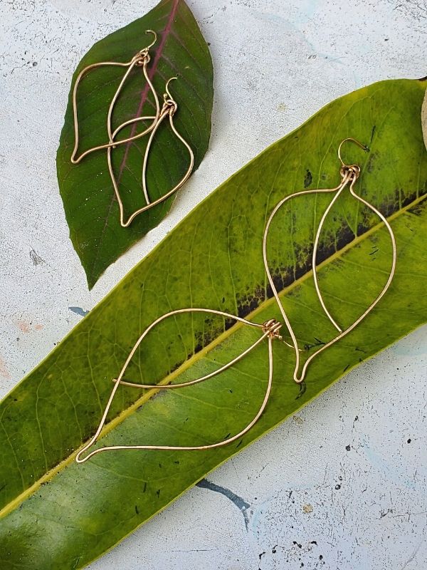 wire leaf earrings on green leaves