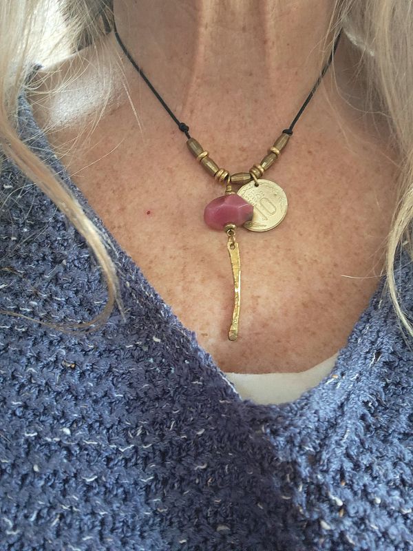 artisan pink gemstone old coin necklace worn with blue sweater